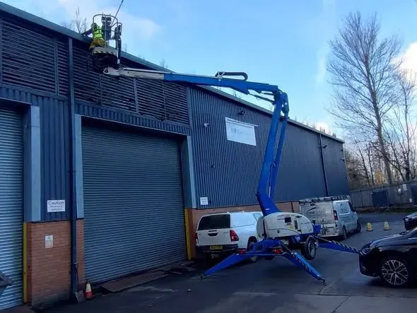 Cherry picker cleaning high level cladding on an industrial unit in Deeside