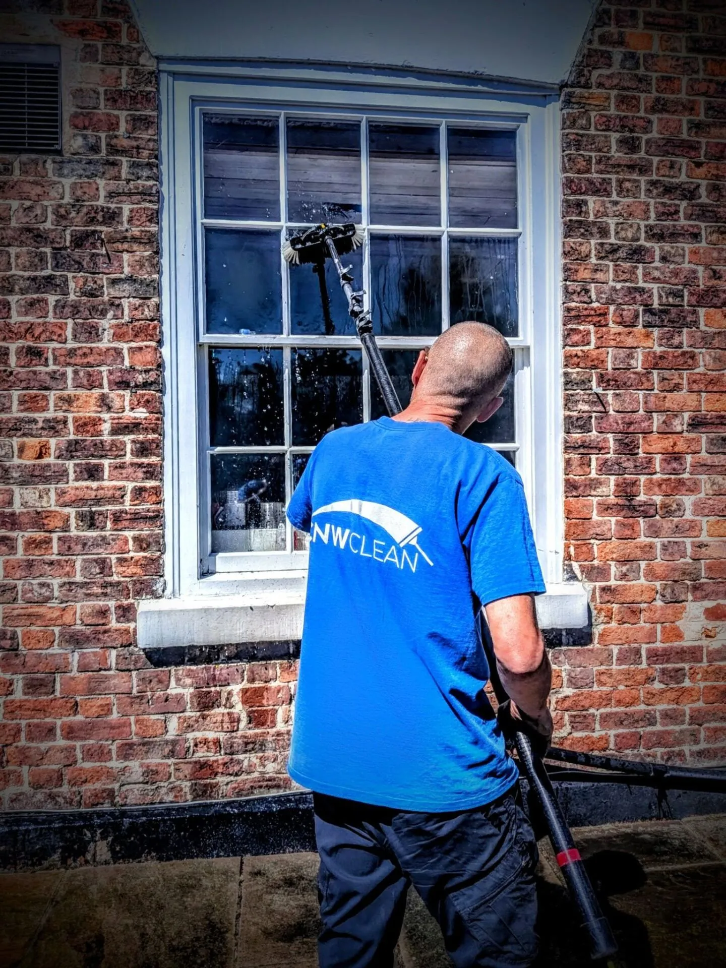 CNW Clean team member cleaning a window