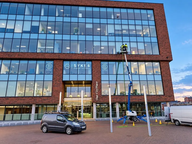 Commercial window cleaning on a glass-fronted office building in Chester from a cherry picker