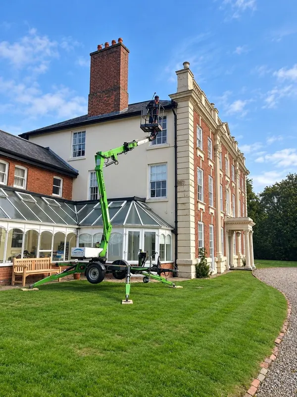 Gutter cleaning from a cherry picker on a large country house