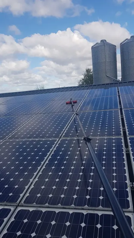 Solar panel cleaning on a farm building roof in North Wales