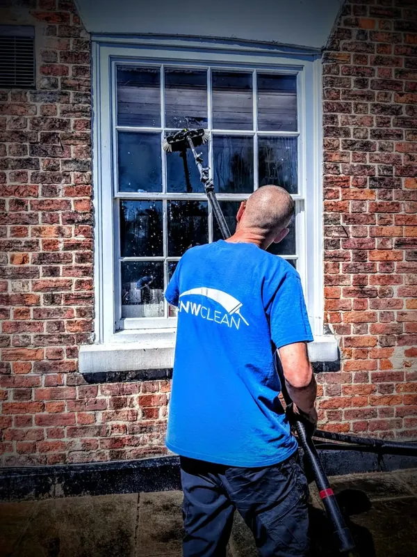 CNW Clean window cleaner using a water-fed pole on a sash window in Chester